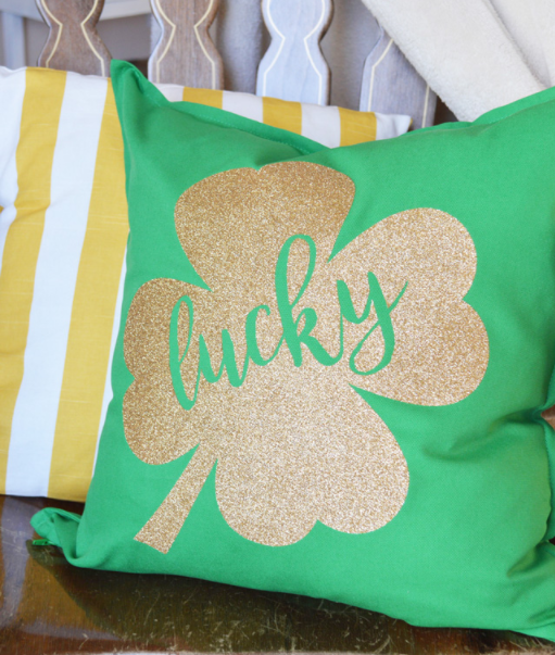 gold shamrock on green pillow with word lucky in green text