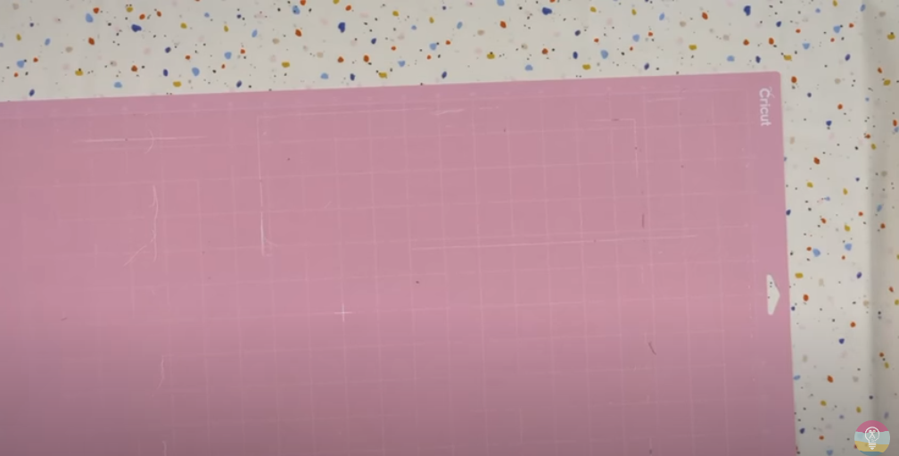 Pink Fabric Grip Cutting Mat Laying On Top Of Terrazzo Patterned Fabric